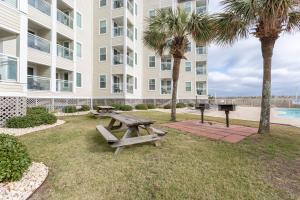 a park with a picnic table and a grill in front of a building at A Place at the Beach by Capital Vacations in Myrtle Beach