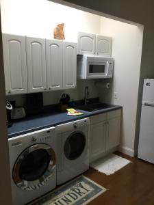 a kitchen with a washing machine and a microwave at A Slice of Paradise in Jensen Beach