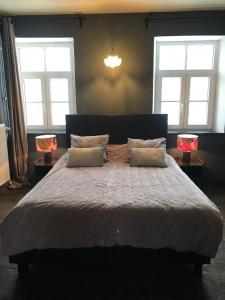 - une chambre avec un grand lit et deux lampes dans l'établissement B&B Aux Quatre Bonniers, à Olne