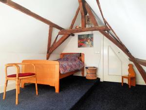 ein Schlafzimmer mit einem Bett und einem Stuhl im Dachgeschoss in der Unterkunft Large Historical Apartment & Canal Terrace in Utrecht