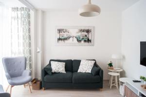 a living room with a green couch and a blue chair at Ekilore - Basquenjoy in Hondarribia