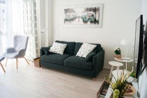 sala de estar con sofá verde y silla en Ekilore - Basquenjoy, en Hondarribia