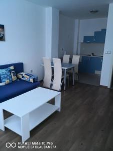 a living room with a couch and a table and chairs at Blue Bay Palace Apart Complex in Pomorie