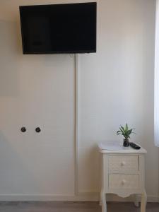 a room with a tv on the wall and a table at Relax City Apartments in Kehl am Rhein