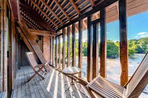 een veranda met 2 stoelen en een tafel bij Moulin du Daumail in Saint-Priest-sous-Aixe