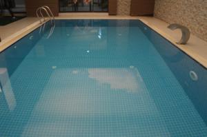 una gran piscina con suelo de baldosa azul en Bal Hotel, en Tirebolu