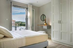 een slaapkamer met een bed en een deur met een balkon bij Julia's Superior Suites in Kástron