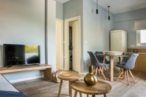 a living room with a table and chairs and a television at Julia's Luxury Suites #1 in Kástron +4 photos