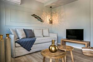 uma sala de estar com um sofá e uma televisão em Julia's Superior Suites em Kástron