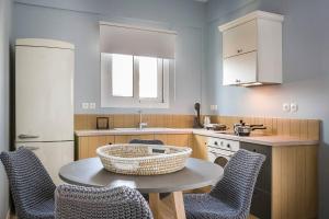 een keuken met een tafel en stoelen en een wastafel bij Julia's Superior Suites in Kástron