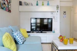 Uma TV ou centro de entretenimento em 49 Abarbanel - By Beach Apartments TLV