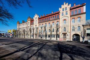 a large brick building with trees in front of it at Urban Two-Level Apartments 13 in Tallinn