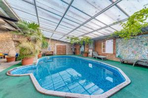 une piscine intérieure avec un toit orné de plantes dans l'établissement Les Cornadis, à Saint-Priest-sous-Aixe