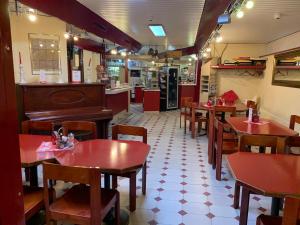 a restaurant with tables and chairs and a piano at Hotel Lyssach in Lyssach