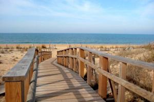 a wooden boardwalk leading to the beach at Leo Punta Umbría in Punta Umbría