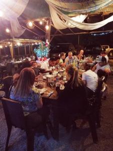 un grupo de personas sentadas en una mesa en un restaurante en Casa Linda Vista, en Caño Seco