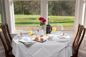 a table with a white table cloth and a window at Langrish House in Petersfield