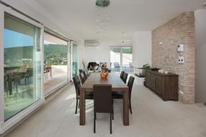 a dining room with a wooden table and chairs at The White House, Brac in Pučišća