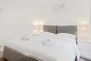 a bedroom with a white bed with towels on it at Sognando Bologna Flat in Bologna