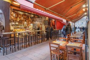a restaurant with tables and chairs in front of a store at Sognando Bologna Flat in Bologna