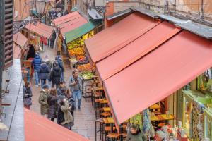 a group of people walking down a street in a market at Sognando Bologna Flat in Bologna +7 photos