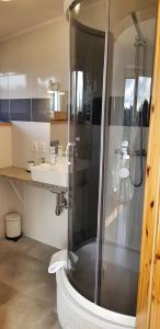 a bathroom with a shower and a sink at Lawendowy Zakątek in Kołczewo