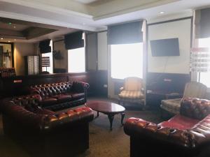 a living room with leather couches and a table at Rose Court Hotel in London