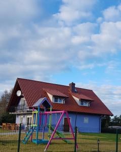 een huis met een speeltuin ervoor bij Lawendowy Zakątek in Kołczewo