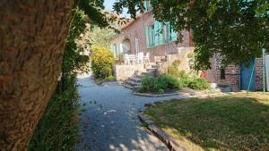 a brick house with a table and chairs in a yard at Les Chambres du Relais in Liettres