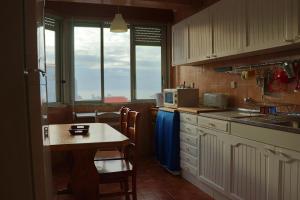 a kitchen with a table and chairs and a counter at Casa Ouriceira, Centro Ericeira in Ericeira