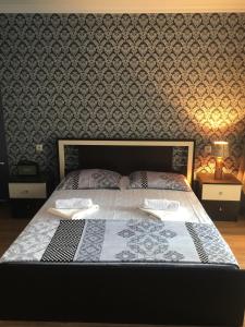een slaapkamer met een groot bed en een muur met patronen bij Summer Home in Kobuleti
