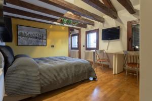 a bedroom with a bed and a desk and a television at Margherita House Venice in Venice