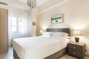 Un dormitorio blanco con una cama grande y una ventana en Athens Homes, en Atenas