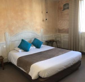 1 dormitorio con 1 cama grande con almohadas azules en Le Thy, en Ploërmel