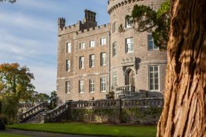 a large stone building with a clock on it's side at Markree Castle in Sligo