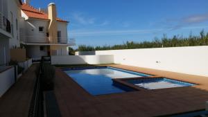 a swimming pool in a yard next to a building at Casas do Mar - Baleal 1 - Sea House in Baleal