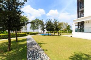 a garden with a gravel path next to a building at Encorp Strand Residences by Airhost in Kota Damansara