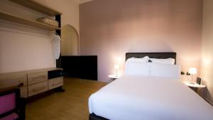 1 dormitorio con 1 cama blanca grande y TV en Junior Suite Balima I B43, en Rabat