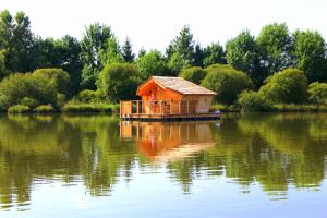 une maison sur un bateau au milieu d'un lac dans l'établissement Village Flottant de Pressac, à Pressac