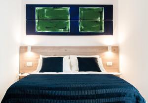 Un dormitorio con una cama con una pintura verde encima. en Demi Rooms, en Nápoles