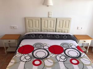 um quarto com uma cama com um cobertor vermelho e branco em EL DUENDE em Las Negras