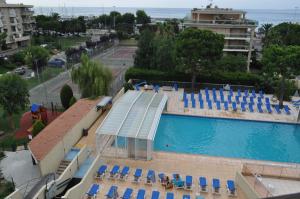 聖羅蘭度瓦的住宿－Inter-Résidences Heliotel Marine，享有带蓝色椅子的游泳池的顶部景致