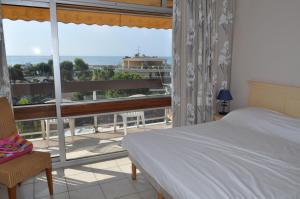 a bedroom with a bed and a balcony with a view at Inter-Résidences Heliotel Marine in Saint-Laurent-du-Var