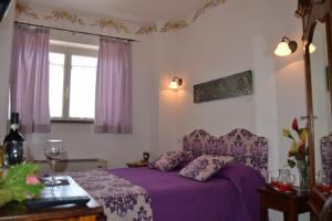 a bedroom with a purple bed and a window at Il Cantuccio in Poggio Murella