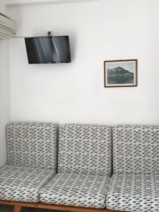a living room with a couch against a white wall at Arillas Studios in Arillas +27 photos