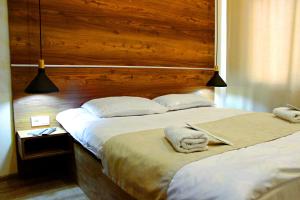 a bedroom with a large bed with a wooden headboard at Apartment Kutaisi in Kutaisi