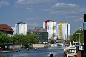 una città con edifici alti e un fiume con una barca di Romantic Style Apartment Berlin Alexanderplatz a Berlino