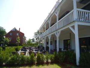 a building with tables and chairs in a yard at Ostseehotel Boltenhagen in Boltenhagen