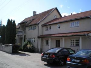 two cars parked in front of a house at Repo Hotel in Kuressaare