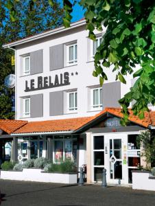 a large white building with a hotel at Logis Hôtel Le Relais in Biscarrosse
